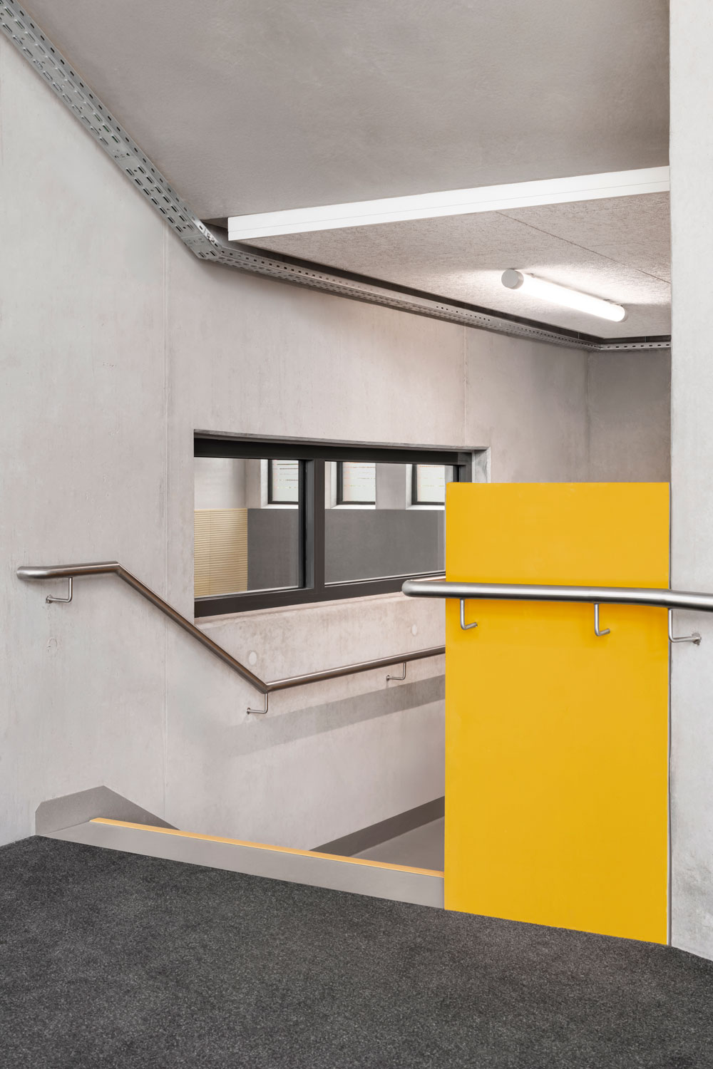 Blick aus dem Treppenhaus durchs verbindende Fenster in die abgesenkte Sporthalle im Erweiterungsneubau des Alten Gymnasium Oldenburg