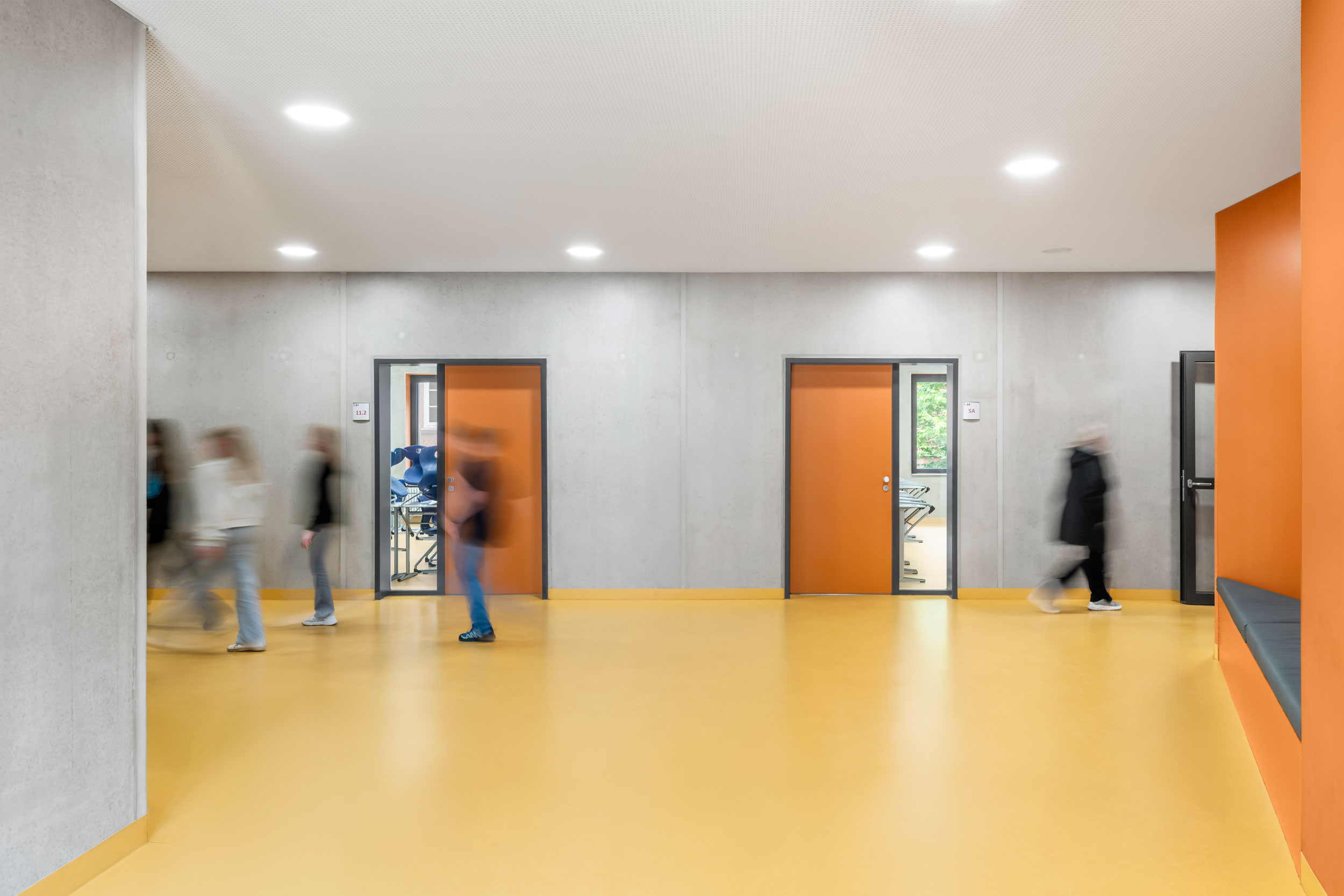 Schüler:innen im Flur mit Blickbeziehungen in die Klassenzimmer im Erweiterungsneubau des Alten Gymnasium Oldenburg