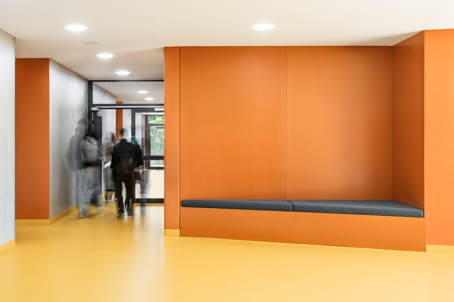 Schüler:innen im Flur mit eingebautem Sitzelement im Erweiterungsneubau des Alten Gymnasium Oldenburg