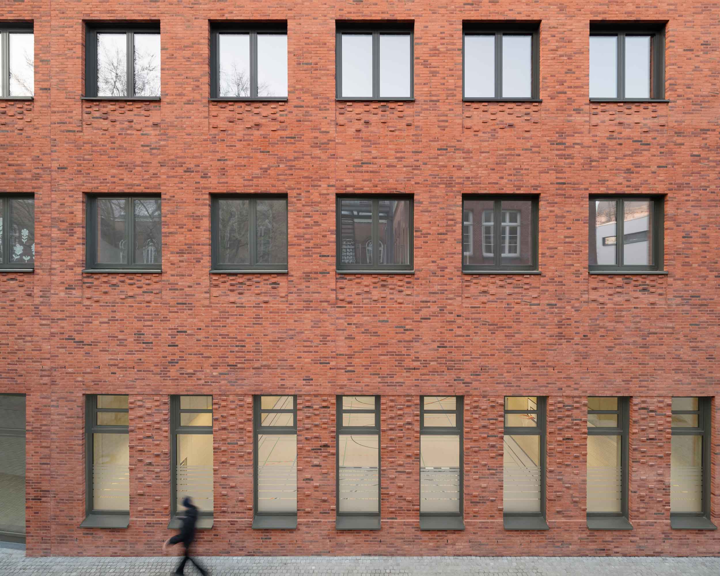 Fassade des Erweiterungsneubaus des Alten Gymnasiums Oldenburg mit Blick auf die abgesenkte Sporthalle