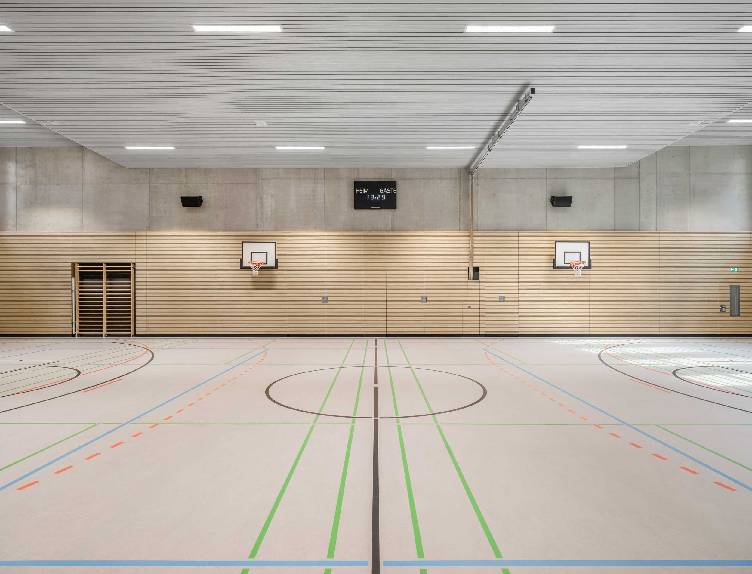 In den Boden abgesenkte Sporthalle mit Holzelementen an der Wand im Erweiterungsneubau des Alten Gymnasium Oldenburg