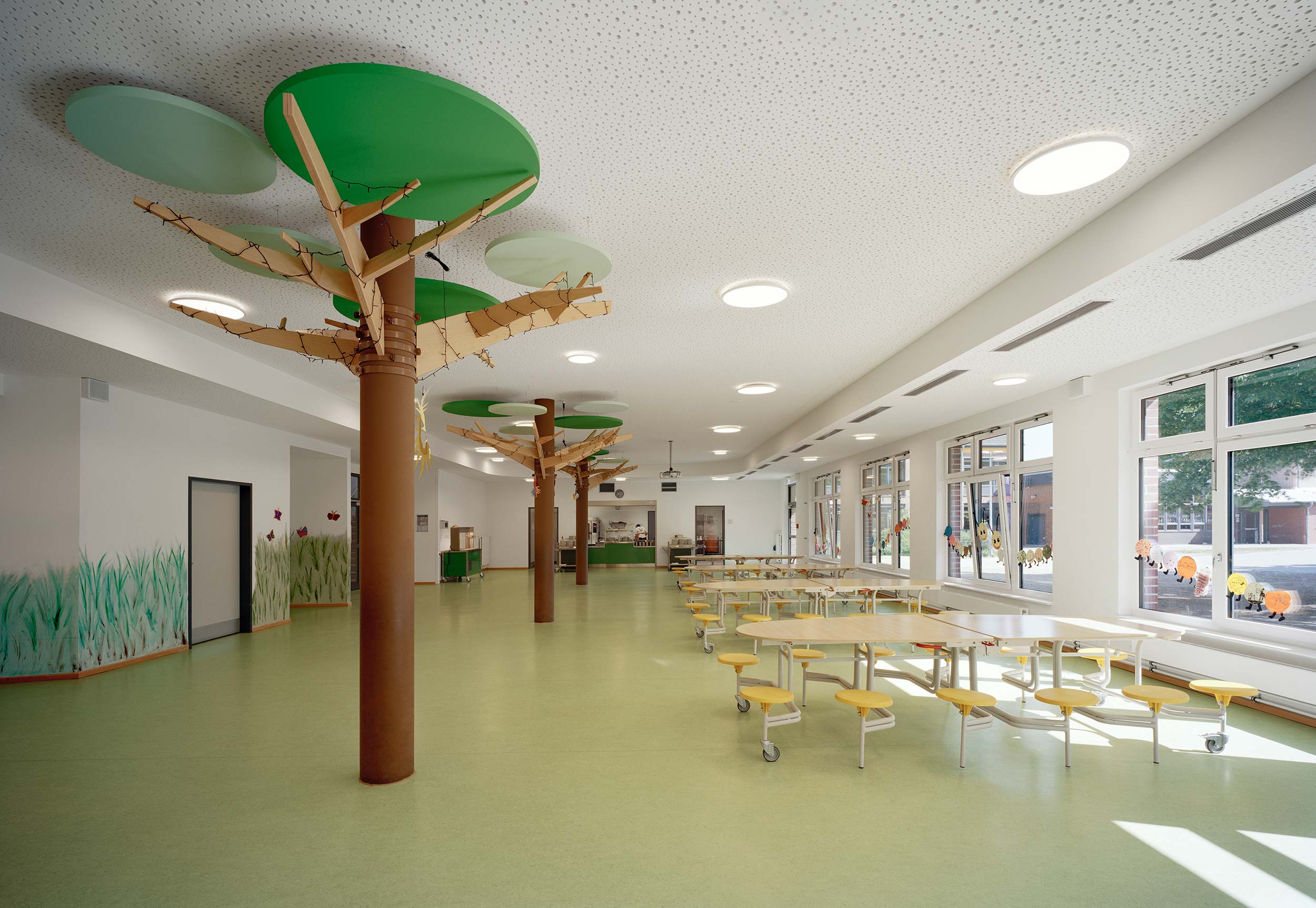 Mensa mit kindgrechter Innenraumgestaltung in Form von Bäumen